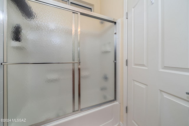 bathroom with shower / bath combination with glass door