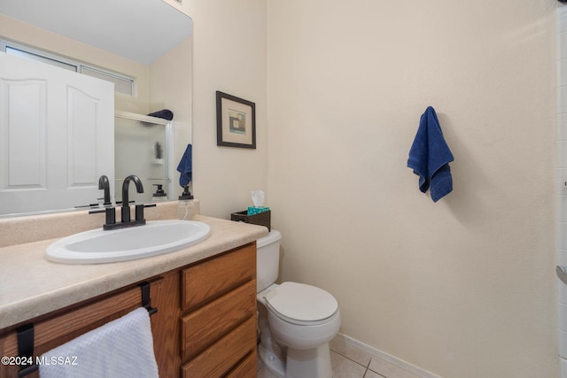 bathroom with toilet, vanity, tile patterned floors, and a shower with door