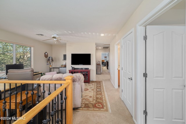 carpeted living room with ceiling fan