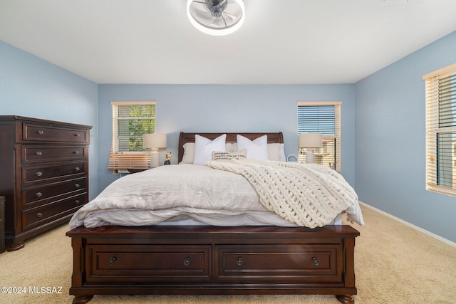 carpeted bedroom featuring multiple windows