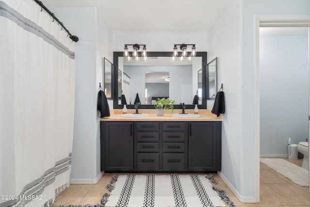 bathroom featuring toilet, vanity, and tile patterned floors