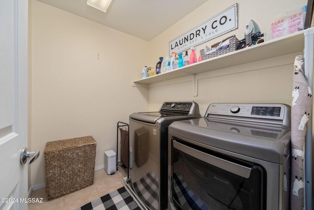 clothes washing area featuring light tile patterned flooring and washing machine and clothes dryer