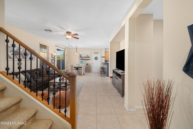 stairway with tile patterned floors and ceiling fan