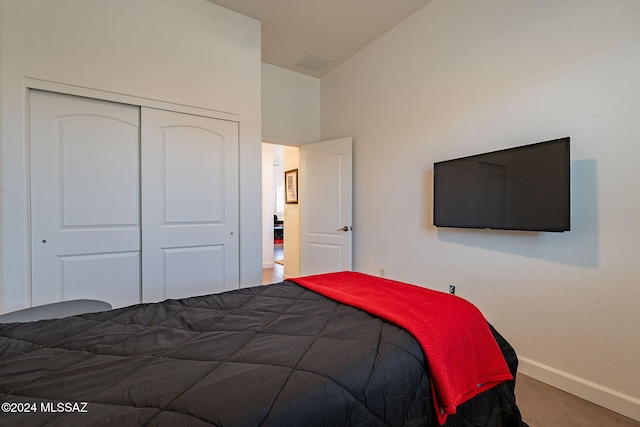 bedroom with carpet floors, high vaulted ceiling, and a closet