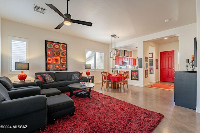 living room with concrete flooring and ceiling fan