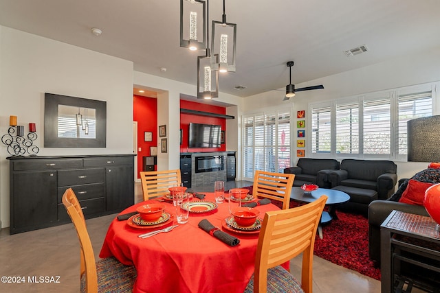 dining area featuring a wealth of natural light, ceiling fan, and concrete floors