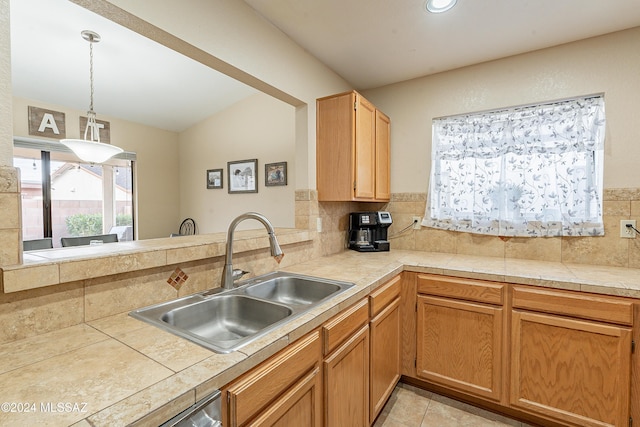 kitchen featuring sink, hanging light fixtures, backsplash, kitchen peninsula, and lofted ceiling