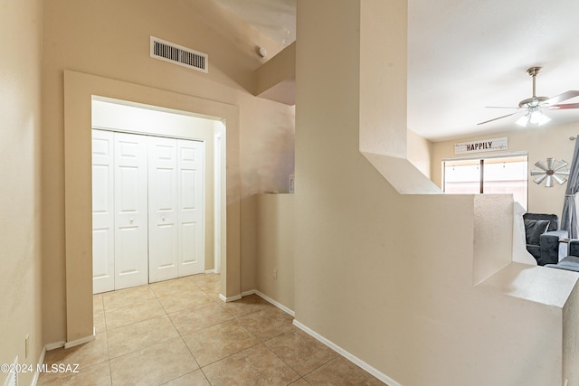 hall with light tile patterned floors and vaulted ceiling