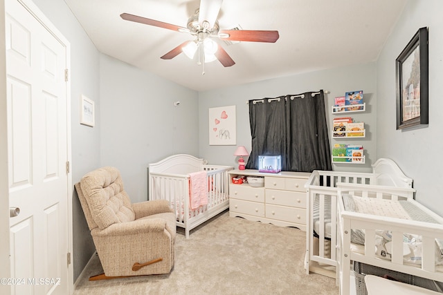 bedroom featuring ceiling fan, carpet floors, and a nursery area