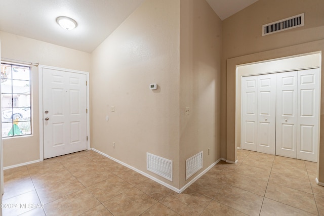 tiled foyer entrance featuring lofted ceiling