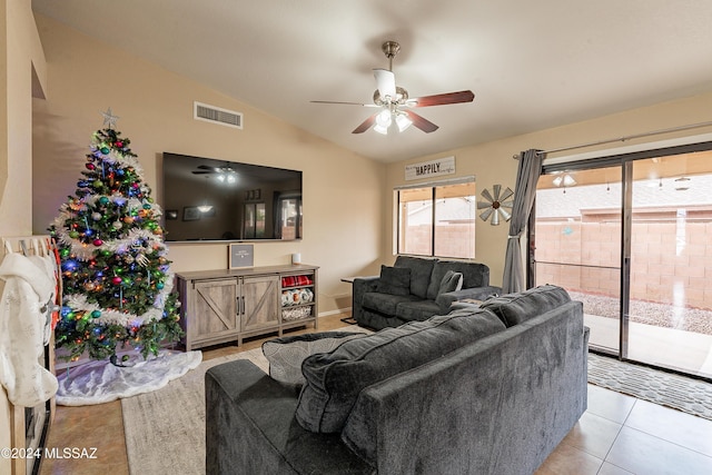 tiled living room with ceiling fan and vaulted ceiling