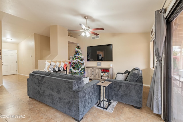 living room with ceiling fan, light tile patterned flooring, and vaulted ceiling