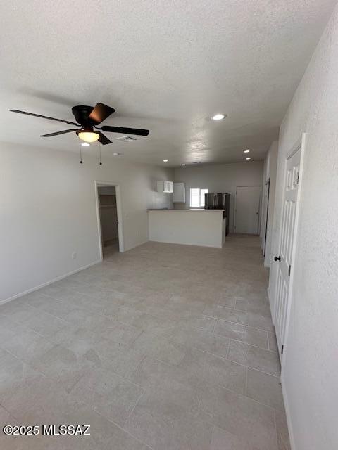 interior space featuring ceiling fan and a textured ceiling