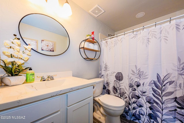 bathroom with walk in shower, vanity, and toilet