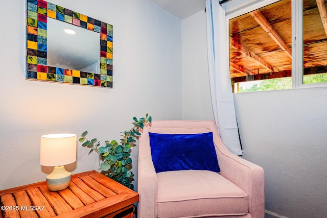 living area with beam ceiling and wood ceiling