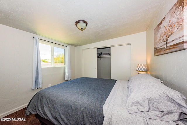 bedroom with carpet, a textured ceiling, and a closet