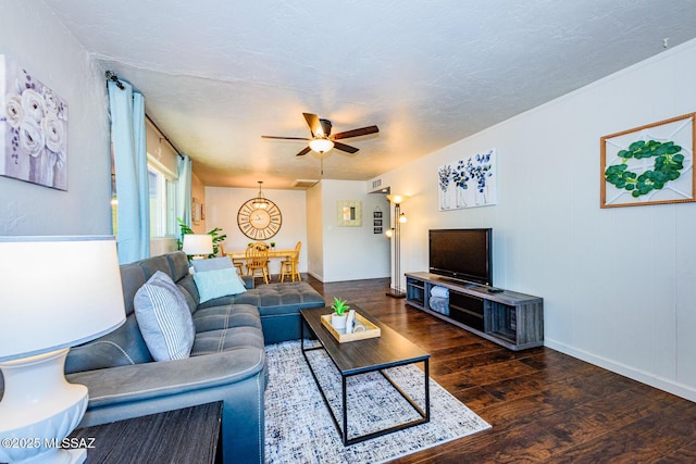 living room with a textured ceiling, dark hardwood / wood-style flooring, and ceiling fan