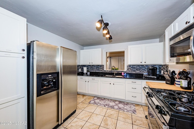 kitchen featuring white cabinets, light tile patterned flooring, sink, and appliances with stainless steel finishes