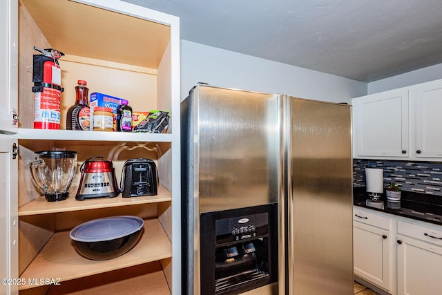 kitchen with backsplash, white cabinetry, and stainless steel refrigerator with ice dispenser