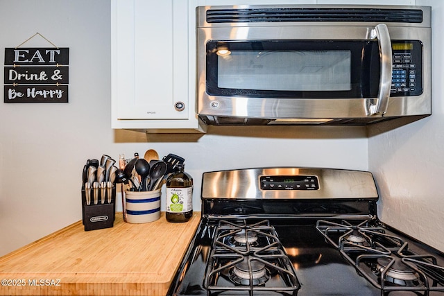 room details featuring butcher block counters, white cabinetry, and appliances with stainless steel finishes