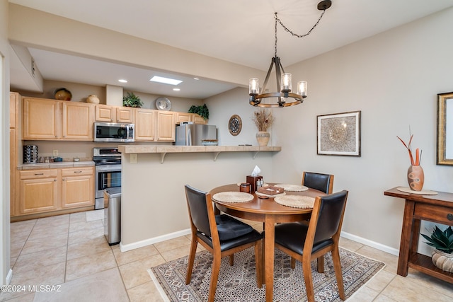 dining area with light tile patterned flooring and a chandelier