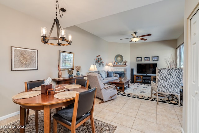 tiled dining area featuring ceiling fan with notable chandelier