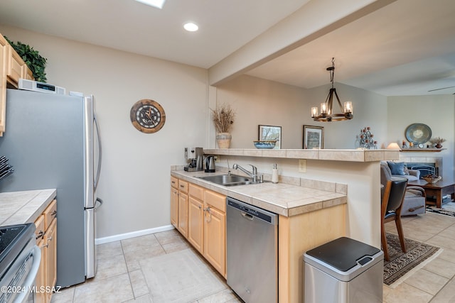 kitchen featuring appliances with stainless steel finishes, tile countertops, pendant lighting, sink, and kitchen peninsula