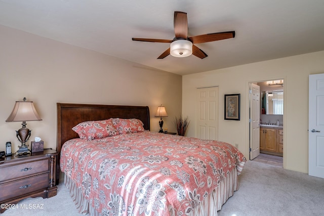 carpeted bedroom with sink, connected bathroom, ceiling fan, and a closet