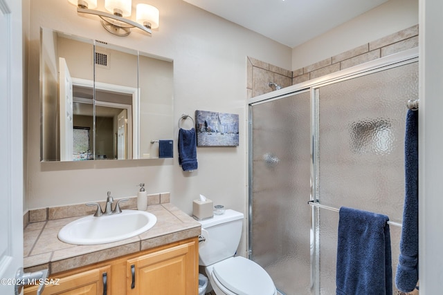 bathroom featuring vanity, toilet, and walk in shower