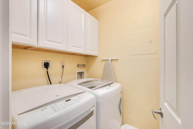 laundry room with cabinets, washer and dryer, and electric panel