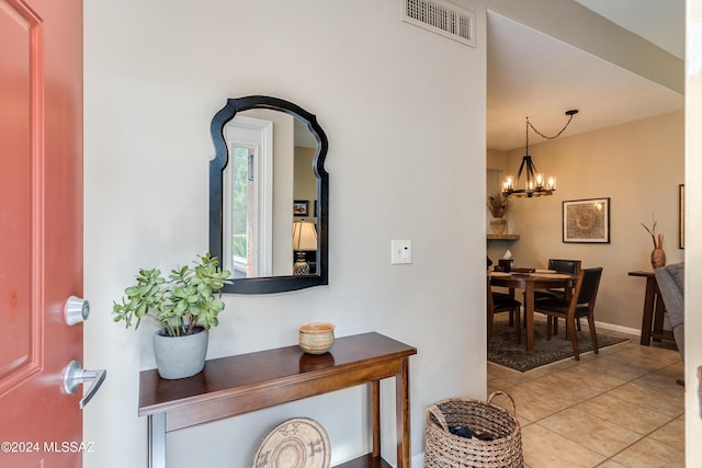 entryway featuring light tile patterned flooring and a chandelier