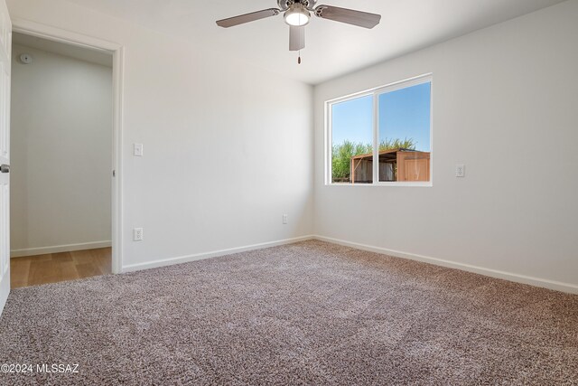 unfurnished room featuring ceiling fan and carpet floors