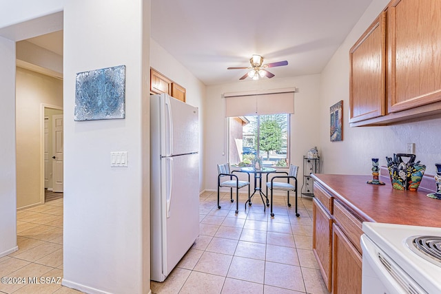 kitchen featuring light tile patterned floors, white appliances, and ceiling fan