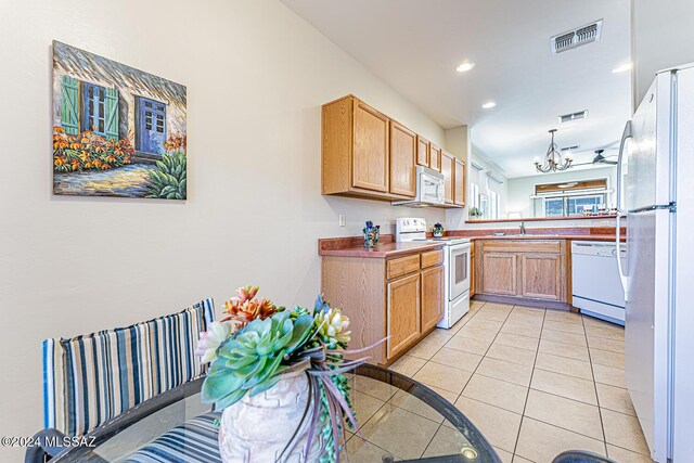 kitchen with white appliances, ceiling fan with notable chandelier, sink, decorative light fixtures, and light tile patterned flooring