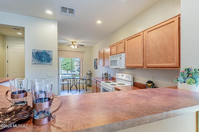 kitchen featuring ceiling fan, light brown cabinets, and white appliances