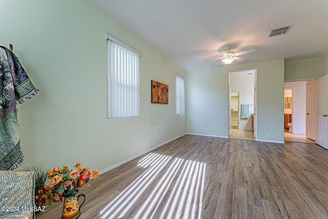 interior space featuring ceiling fan, light hardwood / wood-style floors, and connected bathroom