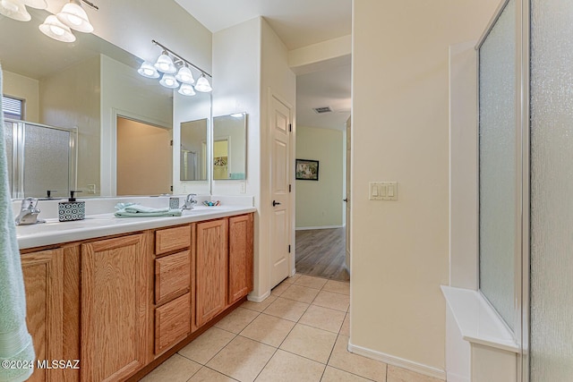 bathroom featuring tile patterned flooring, vanity, and a shower with shower door