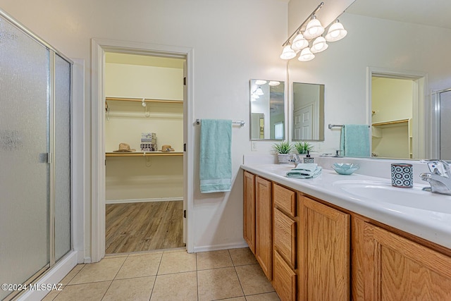 bathroom featuring tile patterned flooring, vanity, and an enclosed shower