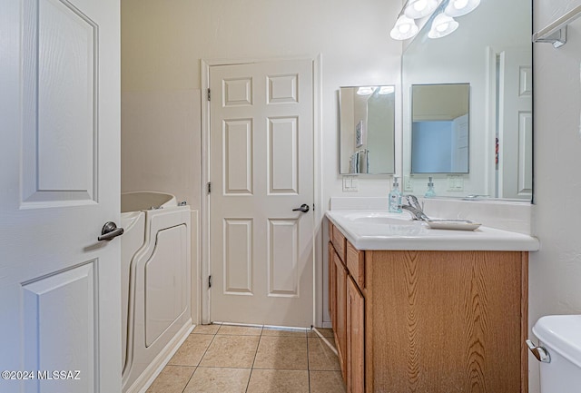 bathroom with washer / dryer, tile patterned flooring, vanity, and toilet