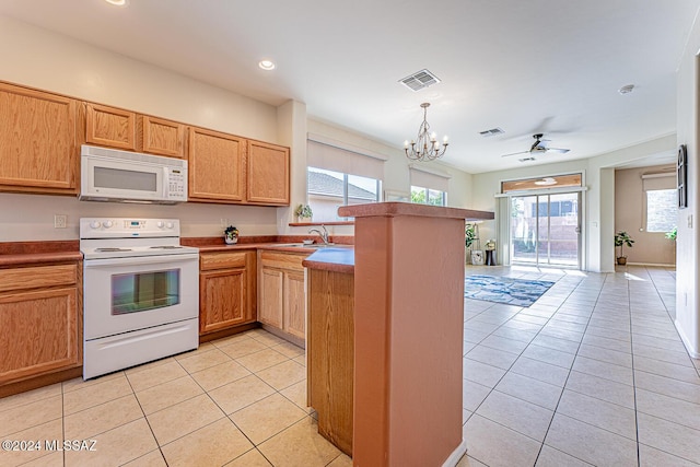 kitchen with kitchen peninsula, ceiling fan with notable chandelier, light tile patterned floors, and white appliances