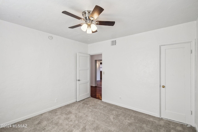 carpeted spare room with ceiling fan