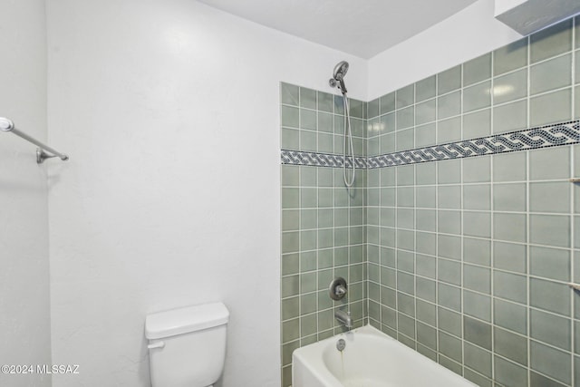 bathroom featuring tiled shower / bath combo and toilet