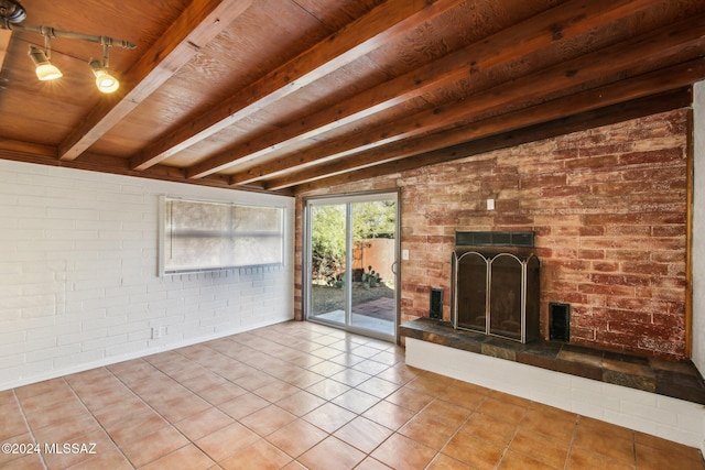 unfurnished living room featuring brick wall, tile patterned floors, beamed ceiling, and wood ceiling