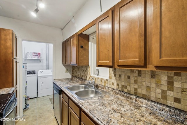 kitchen featuring washing machine and clothes dryer, sink, tasteful backsplash, stainless steel dishwasher, and range