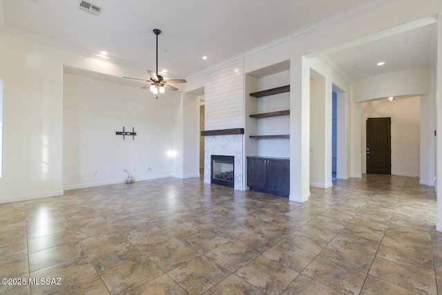 unfurnished living room featuring ceiling fan, built in features, a fireplace, and ornamental molding