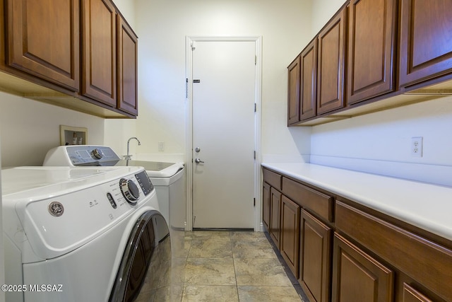 laundry area featuring separate washer and dryer and cabinets