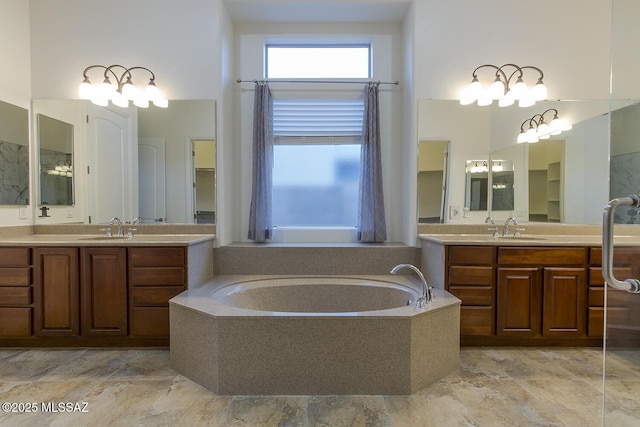 bathroom featuring vanity and a relaxing tiled tub