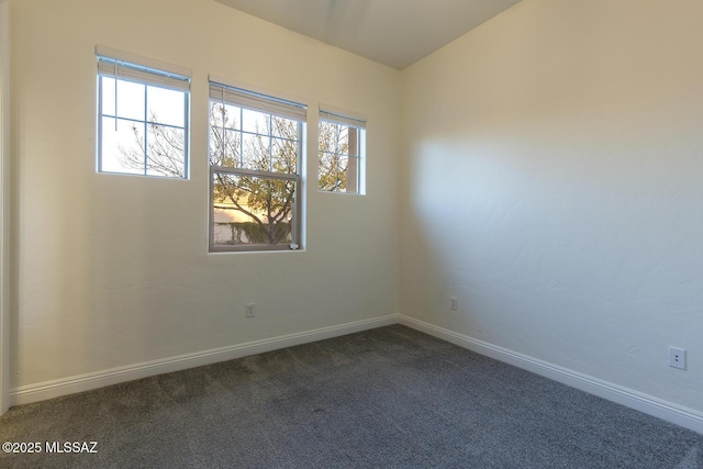 spare room with dark colored carpet