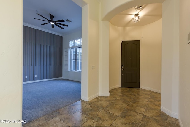 foyer with ceiling fan and crown molding