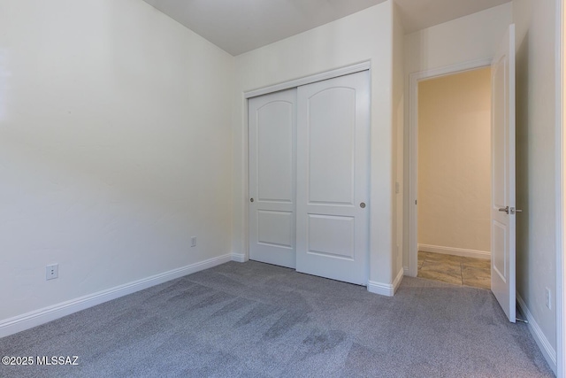 unfurnished bedroom with carpet floors and a closet